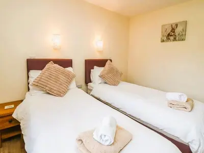 two beds in a room with towels on them at Caban Dulas in Nantmel