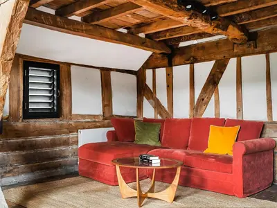 a living room with a red couch and a table at Hayloft Barn in Clifford