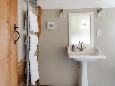 a bathroom with a sink and a mirror at Hayloft Barn in Clifford