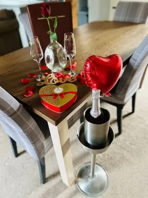 a wooden table with wine glasses and a heart on it at Serafina Cottage in Leominster