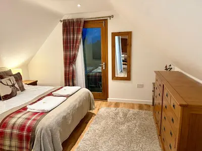 a bedroom with a bed and a dresser and a window at Serafina Lodge in Leominster