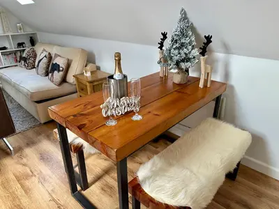 a living room with a wooden table with a christmas tree at Serafina Lodge in Leominster