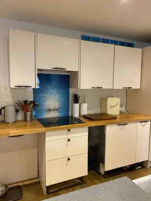 a kitchen with white cabinets and a counter top at The chapel in Machynlleth