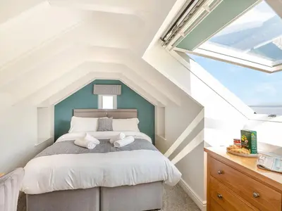 a attic bedroom with a bed and a window at Goppa in Llanfair
