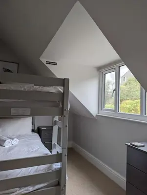 a bedroom with two bunk beds and a window at Pencartref Apartment - 4 Bedrooms, 3 Bathrooms, Sleeps 7-8 in Aberdyfi