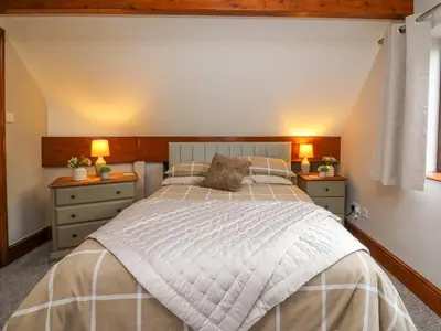a bedroom with a large bed with two night stands at Pondarosa in Llandrindod Wells