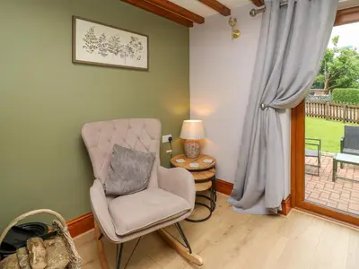 a living room with a chair and a window at Pondarosa in Llandrindod Wells