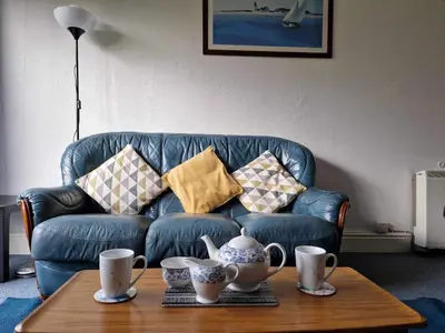 a living room with a blue couch and a coffee table at Swn y nant Barmouth road A496 Llanelltyd in Penmaenpool