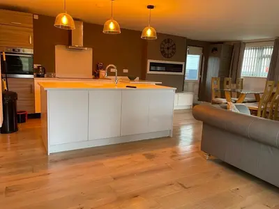 a kitchen with a white island in a living room at Birch Villa in Aberystwyth