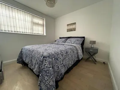 a bedroom with a bed and a table with a lamp at Birch Villa in Aberystwyth