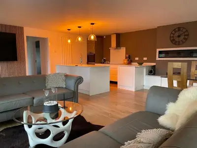 a living room and kitchen with a couch and a table at Birch Villa in Aberystwyth