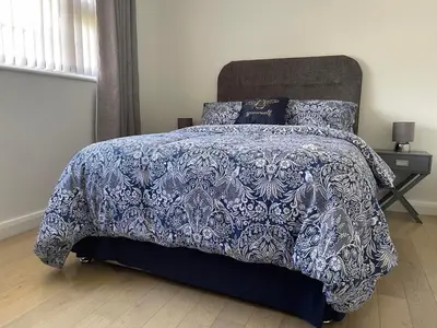a bedroom with a bed with a blue and white comforter at Birch Villa in Aberystwyth