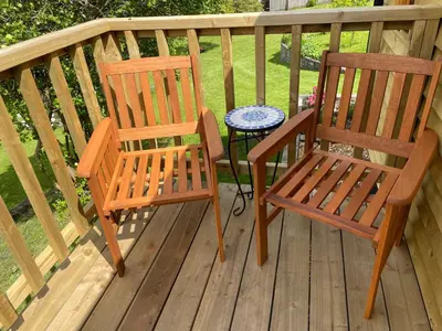 two wooden chairs and a table on a deck at Stylish Shepherds Hut with Amazing Views in Knighton