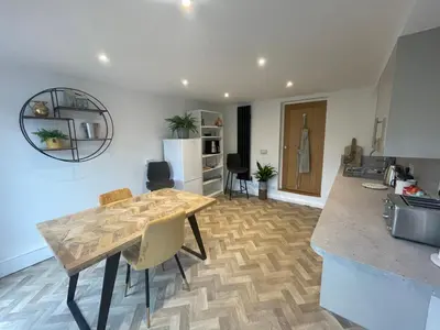 a kitchen and living room with a wooden table and a counter at Stylish Shepherds Hut with Amazing Views in Knighton