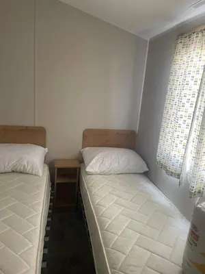 a bedroom with two beds and a window at Caravan by the beach in Borth