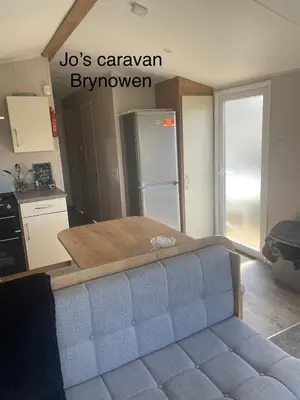 a kitchen with a couch in a kitchen with a refrigerator at Caravan by the beach in Borth