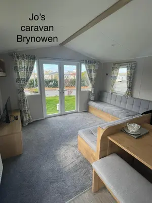 a living room with a couch and a table at Caravan by the beach in Borth