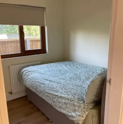 a small bedroom with a bed with a window at Weston pools Lodge with 6 Bedrooms in Oswestry