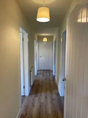 an empty room with a hallway with wood floors and a door at Weston pools Lodge with 6 Bedrooms in Oswestry