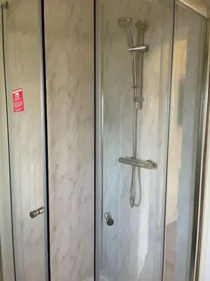 a shower in a bathroom with a glass door at Weston pools Lodge with 6 Bedrooms in Oswestry