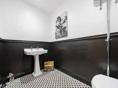 a bathroom with a sink and a black wall at Plas Amherst in Harlech