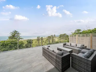 an outdoor patio with two couches on a deck at Plas Amherst in Harlech