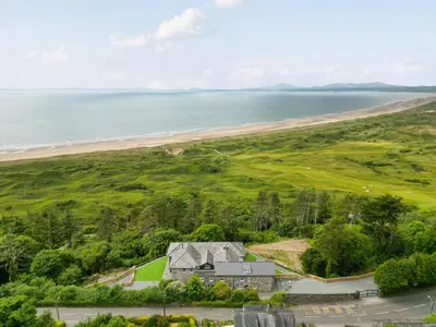 an aerial view of a house and the beach at Valerian Lodge in Harlech