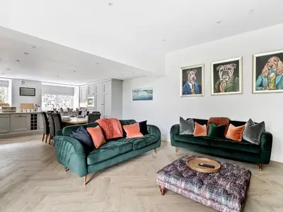 a living room with two green couches and a table at Valerian Lodge in Harlech