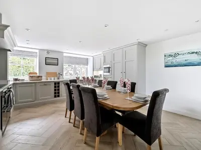 a kitchen and dining room with a wooden table and chairs at Valerian Lodge in Harlech