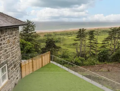 a balcony with a view of the beach at Valerian Lodge in Harlech