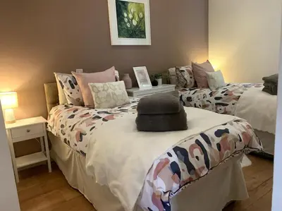 a bedroom with two beds with a hat on top at Tank Barn at Brook House, Nestled in the Welsh Hills, a delightful retreat in Welshpool