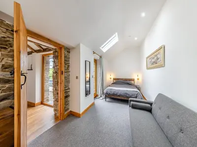 a bedroom with a bed and a couch in a room at Ty Carreg in Llanbadarn-fawr