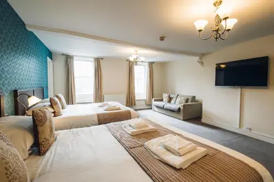 a hotel room with two beds and a flat screen tv at White Lion Royal Hotel in Bala