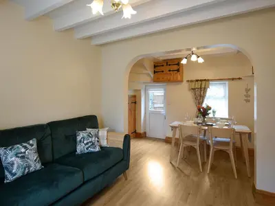 a living room with a green couch and a table at Llys Dedwydd in Dolgellau