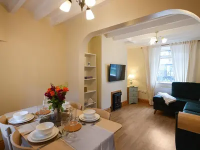 a living room with a table and a couch at Llys Dedwydd in Dolgellau