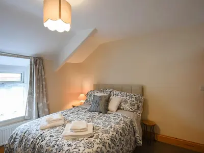 a bedroom with a bed with two towels on it at Llys Dedwydd in Dolgellau