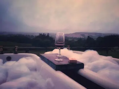 a glass of wine sitting in a bath tub with snow at The Bw thyn - Ceredigion in Lampeter