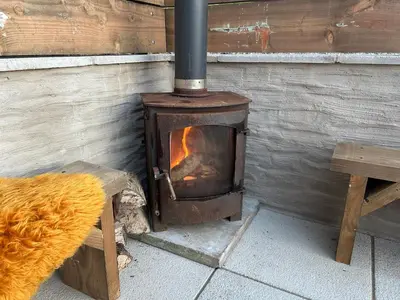 a woodburning stove sitting next to a wooden wall at The Bw thyn - Ceredigion in Lampeter