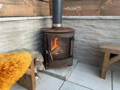 a wood stove sitting next to a wooden wall at The Bw thyn - Ceredigion in Lampeter