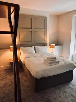 a bedroom with a large bed with two lamps on it at Harley's in Aberystwyth
