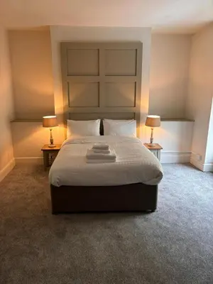 a bedroom with a large bed with two lamps at Harley's in Aberystwyth