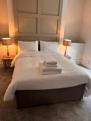 a bedroom with a large bed with two towels on it at Harley's in Aberystwyth