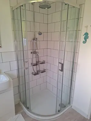 a shower with a glass door in a bathroom at Brynarfor near Aberaeron in Llanon