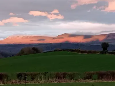 a green field with a mountain in the background at The Slow House Apartments, Llandefalle in Brecon