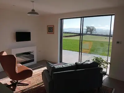 a living room with a couch and a chair and a window at The Slow House Apartments, Llandefalle in Brecon