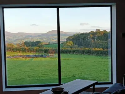a view of a green field from a window at The Slow House Apartments, Llandefalle in Brecon