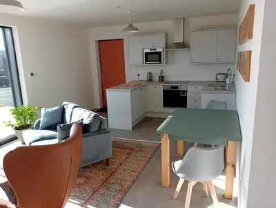 a kitchen and living room with a couch and a table at The Slow House Apartments, Llandefalle in Brecon
