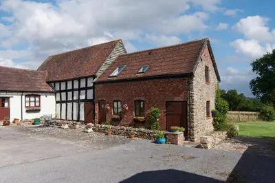 an old brick house with a garage at Granary Cottage a Shropshire haven in Church Stretton