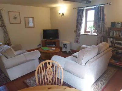a living room with two couches and a tv at Granary Cottage a Shropshire haven in Church Stretton