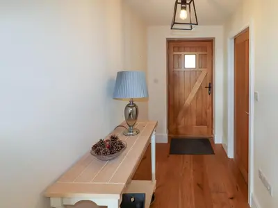 a room with a table with a lamp and a door at Bryn Golau in Llangollen